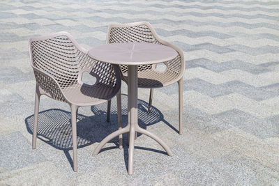 Table and chairs on the tile of an outdoor cafe