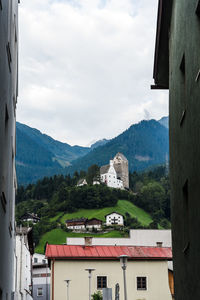 Townscape by mountains against sky