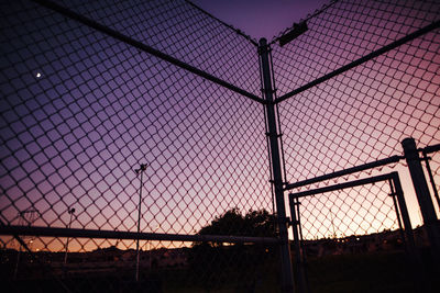 Low angle view of silhouette fence against sky during sunset