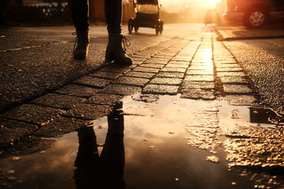 Low section of man standing on wet street