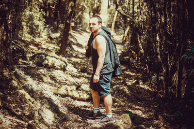 Full length portrait of young man standing in forest