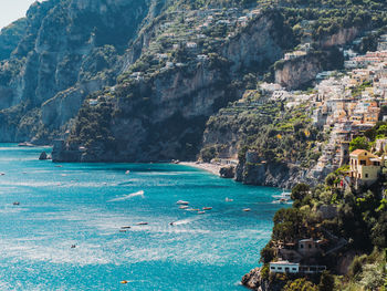 High angle view of sea by mountain against sky