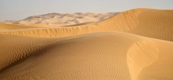 Sand dunes in desert against sky