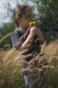 Girl holding dandelion flower in a field