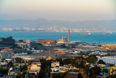 High angle view of townscape by sea against sky