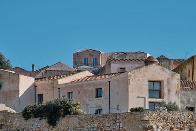 Low angle view of buildings against clear blue sky
