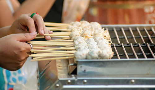 Midsection of person preparing food on barbecue grill