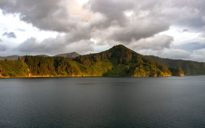 Scenic view of lake by mountains against sky