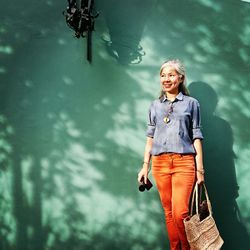 Smiling mid adult woman standing against wall