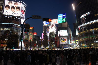 Crowd in city against sky at night