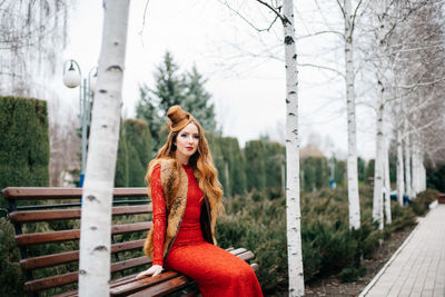 Portrait of woman sitting in park during winter