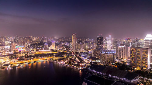 Illuminated buildings in city against sky at night