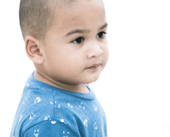 Close-up portrait of cute boy against white background