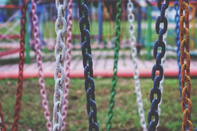 Close-up of chain hanging on metal fence