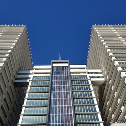 Low angle view of modern buildings against clear blue sky