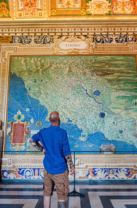 Rear view of man standing against wall