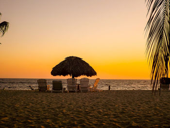 Scenic view of beach against clear sky during sunset