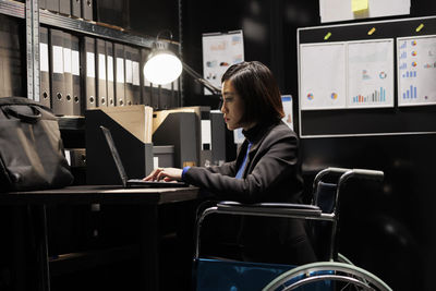 Rear view of man using mobile phone in office