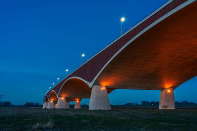 The de oversteek bridge in the dutch city of nijmegen is illuminated in the evening.