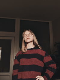 Portrait of a beautiful young woman standing at home