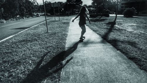 Rear view of child walking on road