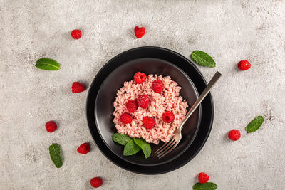 Risotto with raspberries and greek yogurt on grey background.