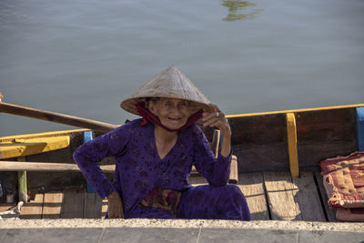 Portrait of woman wearing hat sitting in water