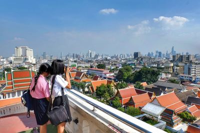 High angle view of woman standing by cityscape against sky