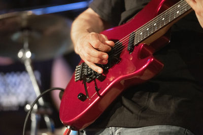 Midsection of man playing guitar