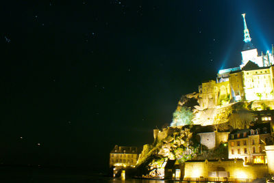 Low angle view of illuminated buildings against sky at night