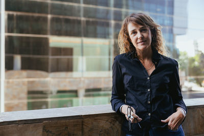 Young woman looking away while standing in city