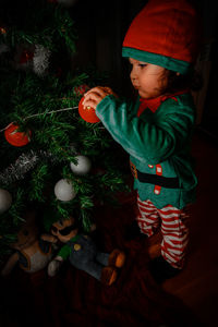 Full length of cute boy holding christmas decoration