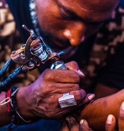 Man making tattoo on hand of customer