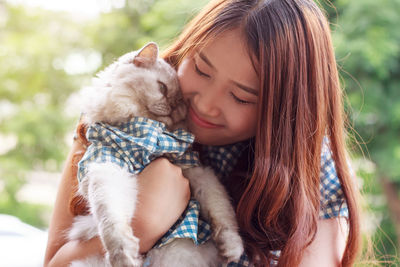 Close-up of woman embracing cat