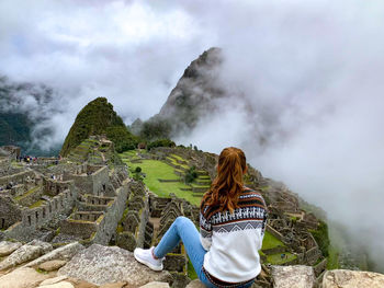 Rear view of girl in front of machu picchu in clouds