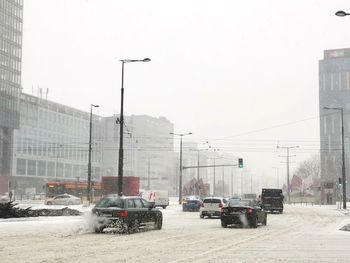 Cars on road in city against sky