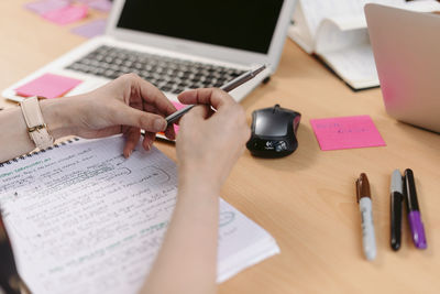 Midsection of man using mobile phone on table