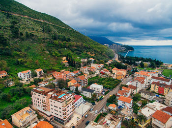 Aerial view of townscape by sea against sky