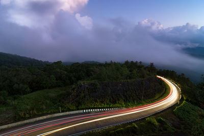 Beautiful road on the way up to inthanon national park at dusk, fog in the forest. long exposure.