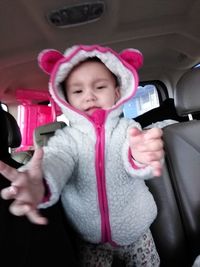 Portrait of cute baby girl in car