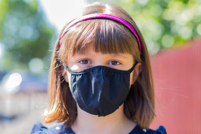 Close-up portrait of girl wearing mask