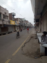 People on street amidst buildings in city