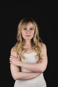 Portrait of beautiful young woman against black background