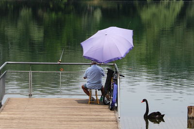 Rear view of man and woman on lake