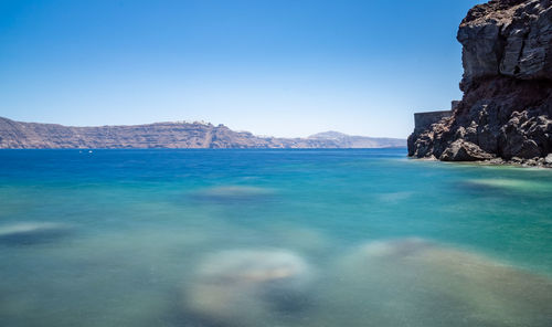 View from the beach of the cliff and the santorini caldera. sunny day, sky without clouds