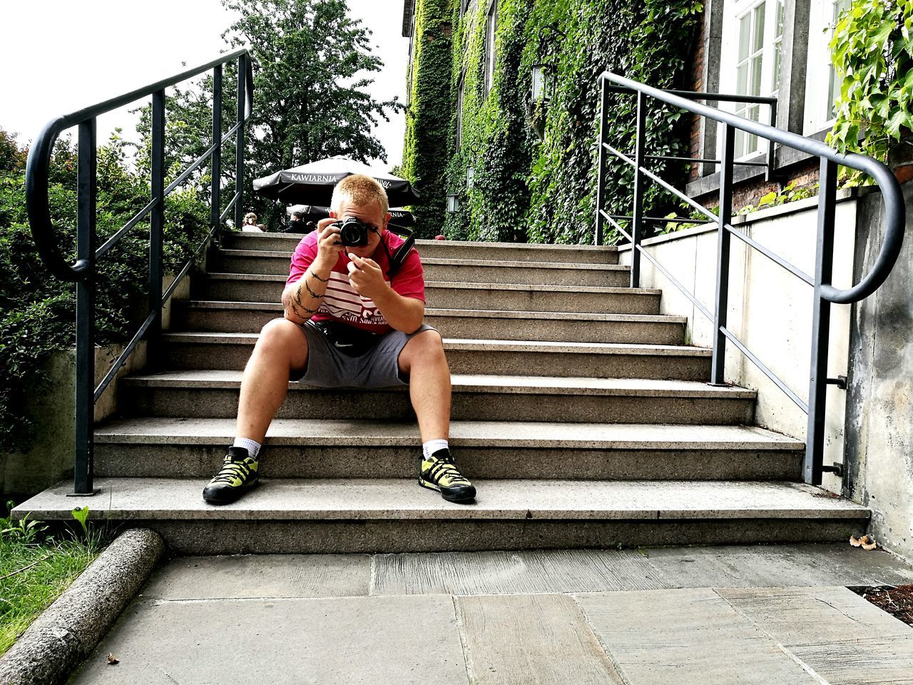 WOMAN SITTING ON STEPS WITH UMBRELLA