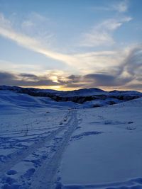 Snow covered landscape against sky