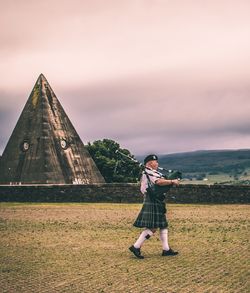 Full length of woman standing on grass against sky