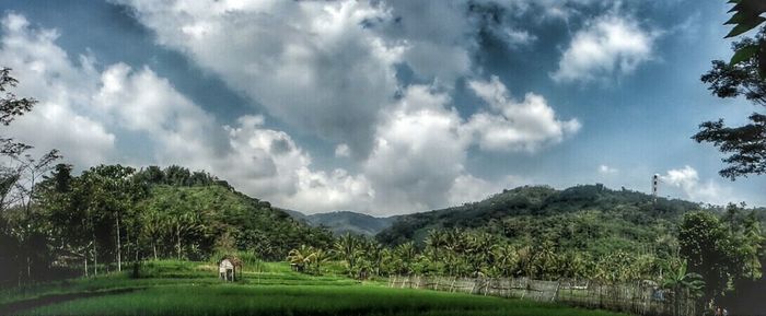Scenic view of mountains against cloudy sky