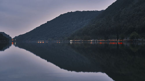 Scenic view of lake by mountains against sky